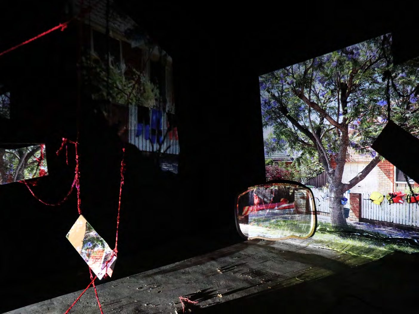 Projection of a tree and hanging fragments in a darkened gallery